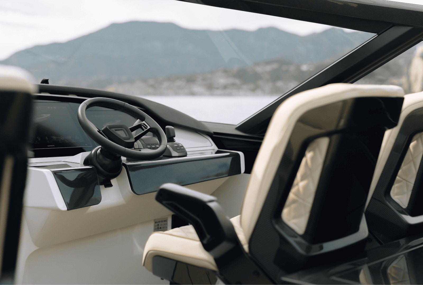 Luxurious boat cockpit with beige seats, a sleek steering wheel, and a digital display panel. Scenic mountain view in the background.